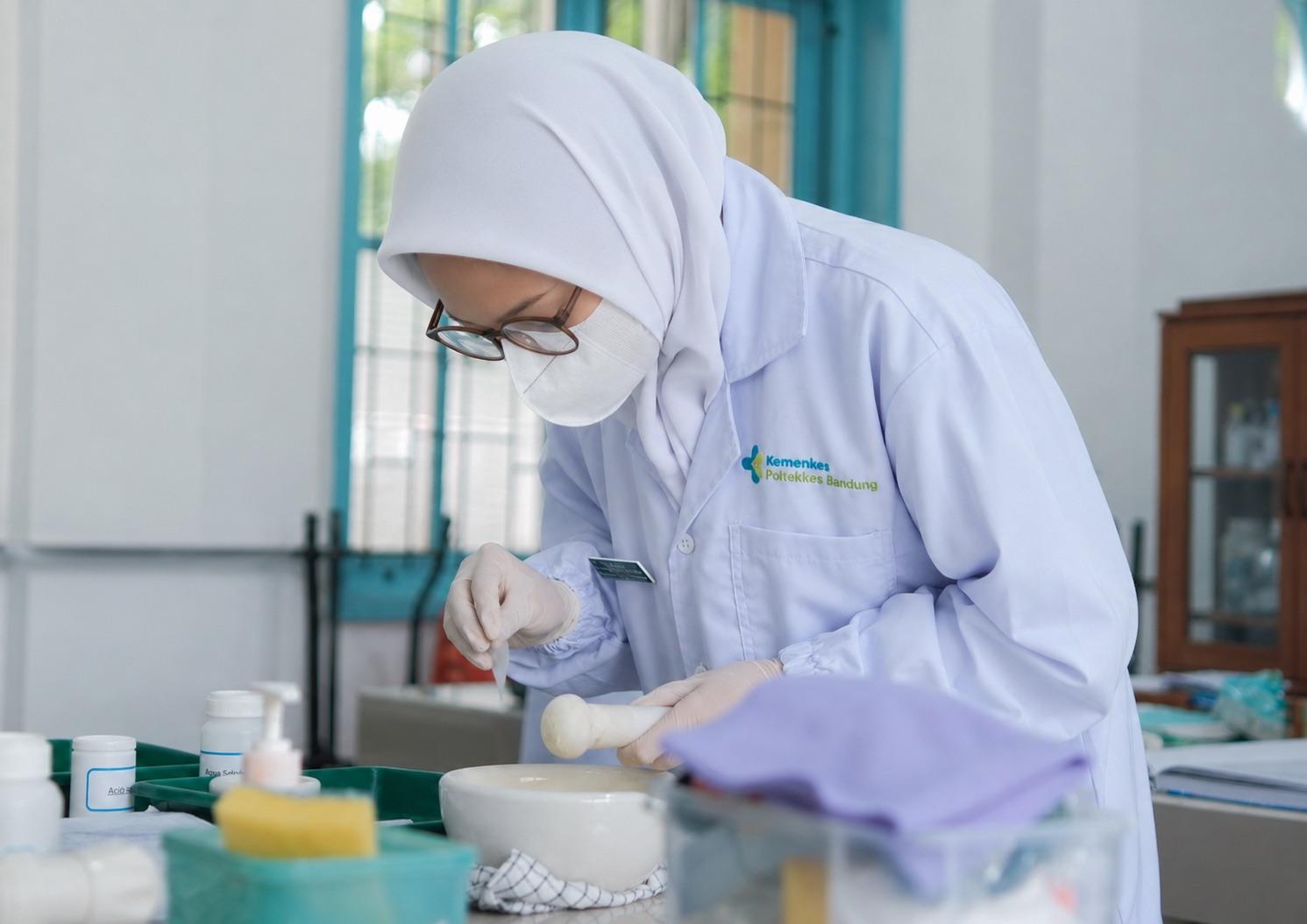 Mahasiswi Jurusan Farmasi melakukan praktikum di laboratorium